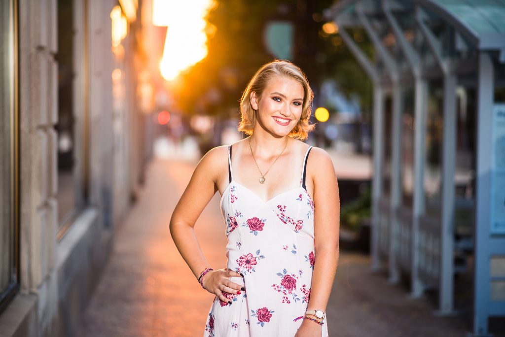 Capturing a milestone moment: A senior girl in a stylish dress, radiating confidence and joy, commemorating her high school journey with a timeless and elegant portrait.