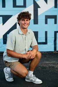Full-length city-style senior photo of Graham on Madison’s Monroe Street